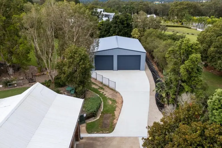 Drone image of a caravan and boat storage shed with curved driveway and twin Ironstone roller doors in a bushland setting.