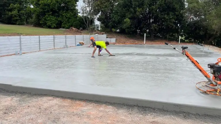 Debret crew finishing concrete slab for caravan and boat storage shed with trowel and finishing tools.
