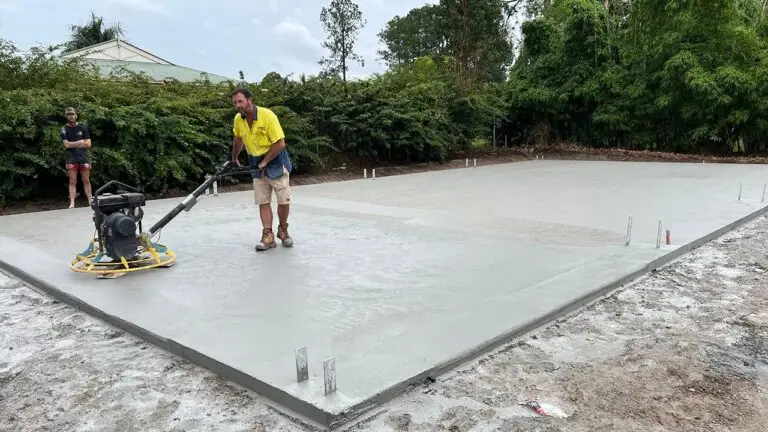 Worker using power trowel on workshop shed slab in Forestdale