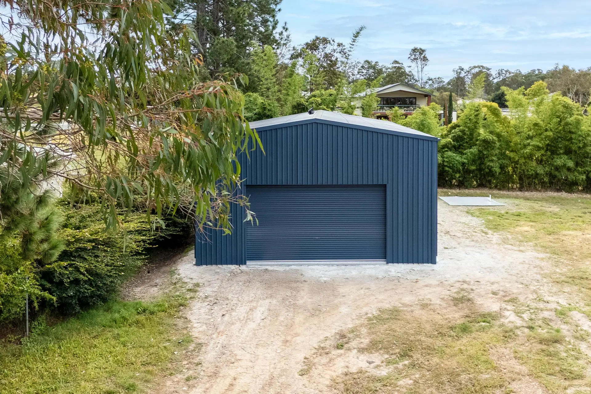 Epoxy floor workshop shed in Forestdale with Deep Ocean COLORBOND walls and wide roller door