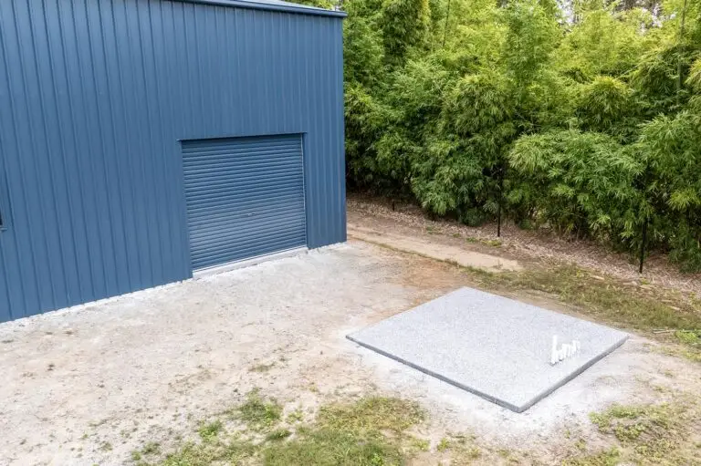 Workshop shed in Forestdale with roller door and matching epoxy slab for water tank